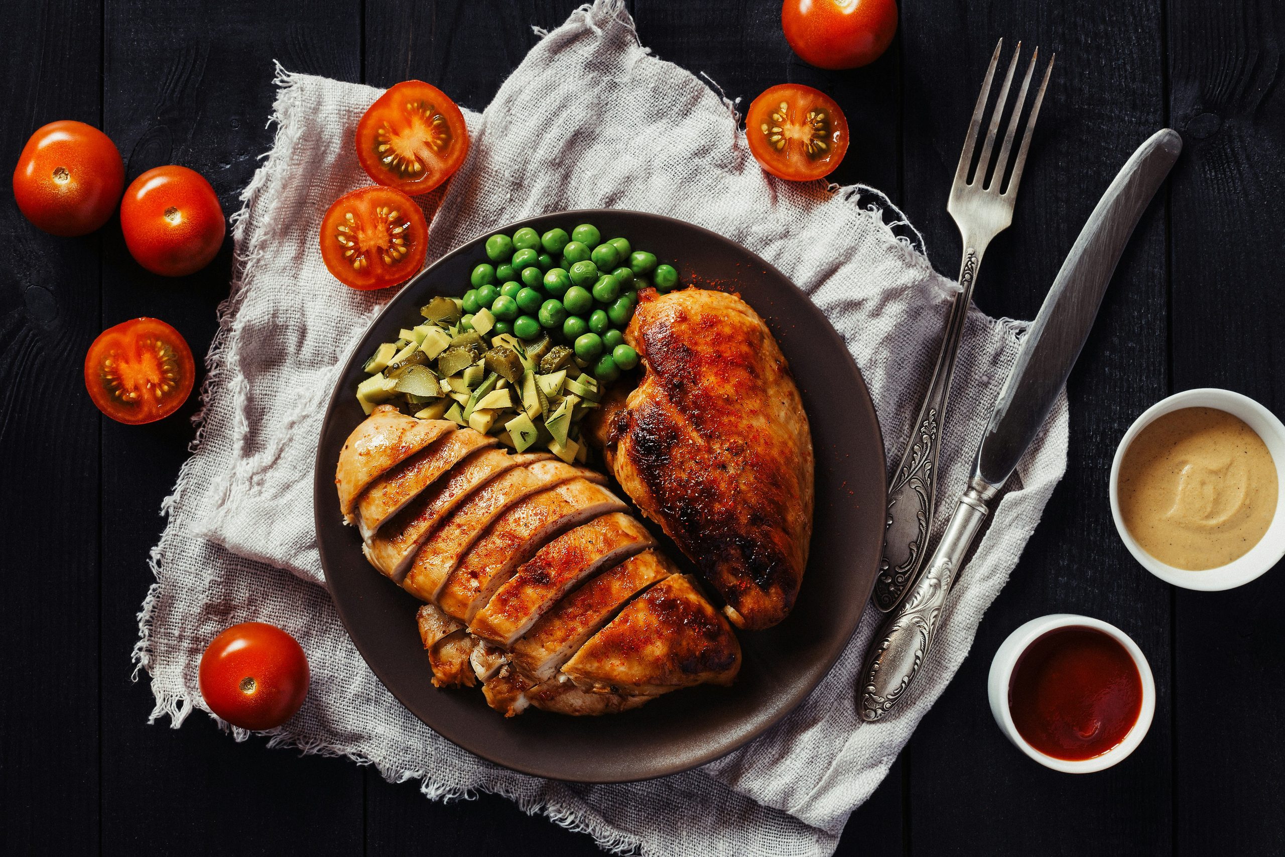 Grilled chicken breast with peas and vegetables representing a high-protein meal and blood sugar